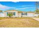 Ranch style home with white brick facade, blue shutters, and a well-maintained lawn at 5810 Town N Country Blvd, Tampa, FL 33615