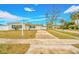 Front view of a ranch home with driveway and mature trees in the background at 5810 Town N Country Blvd, Tampa, FL 33615