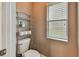 Small bathroom with toilet and shelving unit at 6944 Runner Oak Dr, Wesley Chapel, FL 33545