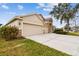 House exterior with a three-car garage and stone accents at 6944 Runner Oak Dr, Wesley Chapel, FL 33545