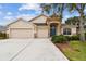 House exterior featuring a three-car garage and stone accents at 6944 Runner Oak Dr, Wesley Chapel, FL 33545