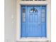 Inviting blue front door with sidelights and arched window at 6944 Runner Oak Dr, Wesley Chapel, FL 33545