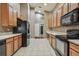 Kitchen with wood cabinets and black appliances at 6944 Runner Oak Dr, Wesley Chapel, FL 33545