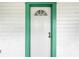 White front door with a green frame and arched window at 710 Seminole St, Clearwater, FL 33755