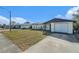 Front view of a ranch home with a white exterior and a spacious yard at 7310 Oakshire Dr, Port Richey, FL 34668