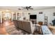 Living room featuring brown couches, a large TV, and a ceiling fan at 7310 Oakshire Dr, Port Richey, FL 34668