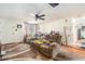 Living area with a brown reclining sofa, ceiling fan, and wood flooring at 7310 Oakshire Dr, Port Richey, FL 34668