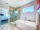 Modern bathroom with a soaking tub, walk-in shower, and tiled floors at 818 W Adalee St, Tampa, FL 33603