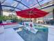 Inviting pool area with covered patio, lounge chairs, and red umbrella at 818 W Adalee St, Tampa, FL 33603