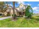 Two-story house with tan exterior, two-car garage, and landscaping at 10112 Haverhill Ridge Dr, Riverview, FL 33578