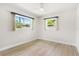 Well-lit bedroom with light wood flooring and two windows at 10971 90Th Ave, Seminole, FL 33772