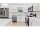 Modern kitchen with white cabinets, quartz countertops, and stainless steel appliances at 10971 90Th Ave, Seminole, FL 33772