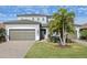 Two-story house with gray siding, brown garage doors, and palm trees at 11815 Perennial Pl, Lakewood Ranch, FL 34211