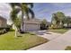 Tan house with palm trees and a neatly manicured lawn at 12311 Silton Peace Dr, Riverview, FL 33579