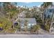 Aerial view of a light blue beach cottage nestled among palm trees at 128 Bay Plz, Treasure Island, FL 33706