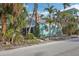 Charming light blue cottage with a screened porch, nestled among palm trees at 128 Bay Plz, Treasure Island, FL 33706