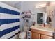 Bathroom with shower/tub combo, wood vanity, and striped curtain at 13458 Graham Yarden Dr, Riverview, FL 33579