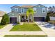 Two-story house with a green exterior, two-car garage, and palm tree at 13458 Graham Yarden Dr, Riverview, FL 33579