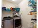 Well-equipped laundry room with washer, dryer, and ample shelving at 13458 Graham Yarden Dr, Riverview, FL 33579