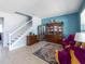 Living room with tiled floors, wooden cabinet, and staircase at 13458 Graham Yarden Dr, Riverview, FL 33579