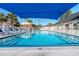 Refreshing community swimming pool with blue shade sail and steps at 1400 Gandy N Blvd # 506, St Petersburg, FL 33702