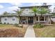 Two-story house with gray siding, palm trees, and a walkway at 1534 Wexford N Dr, Palm Harbor, FL 34683