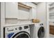 Bright laundry room with front-load washer and dryer, marble countertop, and ample cabinetry at 1534 Wexford N Dr, Palm Harbor, FL 34683