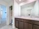 Double vanity bathroom with linen closet and view of hallway at 16779 Sunburst Lake St, Wimauma, FL 33598