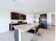 Spacious kitchen featuring dark cabinets, granite countertops, and an island at 16779 Sunburst Lake St, Wimauma, FL 33598