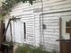 White wood exterior of a small house showing some paint peeling and overgrown vegetation at 1820 E Sitka St, Tampa, FL 33604