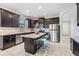 Modern kitchen with dark cabinets, granite countertops and island at 19724 Post Island Loop, Land O Lakes, FL 34638