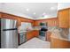 Condo kitchen with wood cabinets, granite counters, and stainless steel appliances at 301 Cordova Grn, Seminole, FL 33777