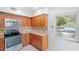 Condo kitchen with wood cabinets, granite counters, and stainless steel appliances at 301 Cordova Grn, Seminole, FL 33777