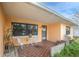 Covered front porch with tiled flooring and a small seating area at 404 87Th Ave, St Pete Beach, FL 33706