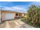 Front view of a single-story house with a white garage door at 404 87Th Ave, St Pete Beach, FL 33706