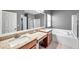 Bathroom with double vanity, granite countertop and soaking tub at 4506 Mapletree Loop, Wesley Chapel, FL 33544