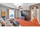Bright living room featuring hardwood floors, a large TV stand, and comfortable seating at 4506 Mapletree Loop, Wesley Chapel, FL 33544