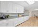 Modern kitchen with white cabinets, granite countertops, and wood-look flooring at 4519 S Hesperides St, Tampa, FL 33611