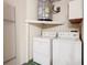 Convenient laundry area with washer, dryer, and shelving at 5832 Red Cedar Ln, Tampa, FL 33625