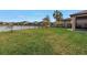 Landscaped backyard with grassy area and lake view at 6216 Kevesta Ave, Palmetto, FL 34221