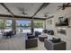 An outdoor patio area featuring cushioned seating, a fireplace, ceiling fans, and a view of the nearby pool at 6216 Kevesta Ave, Palmetto, FL 34221