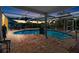 Evening view of a kidney-shaped pool with screened enclosure at 6518 Senegal Palm Way, Apollo Beach, FL 33572