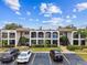 Two-story condo building with parking and lush landscaping at 7701 Starkey Rd # 105, Seminole, FL 33777