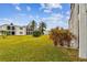 Spacious grassy backyard with tropical landscaping and building view at 7701 Starkey Rd # 105, Seminole, FL 33777