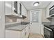 Kitchen with white cabinets, granite countertops, and black appliances at 7701 Starkey Rd # 105, Seminole, FL 33777