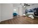 Spacious bedroom with wood floors, a window seat, and a scenic wall mural at 8131 Spring Forest Ln, Wesley Chapel, FL 33544