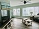 Living room with gray sectional sofa, wood-look floors, and large windows at 1004 Peninsula Ave, Tarpon Springs, FL 34689