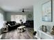 Bright living room with gray leather furniture, wood-look floors, and large windows at 1004 Peninsula Ave, Tarpon Springs, FL 34689