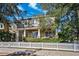 Two-story house with front porch, stone accents, and white picket fence at 10515 Fenceline Rd, New Port Richey, FL 34655