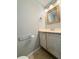 Small bathroom with distressed-white vanity and a framed mirror at 11356 Stratton Park Dr, Temple Terrace, FL 33617